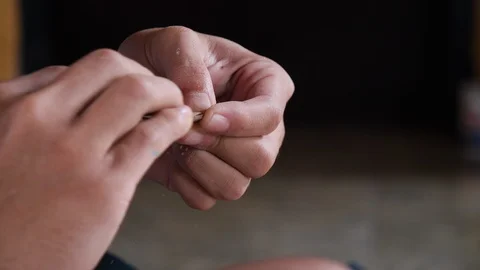 Slow motion shot of local man sanding wooden pendants with sandpaper, Bali Stock Footage 140252803
