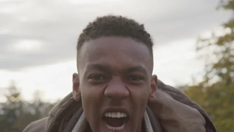 Slow motion shot of Mad Young African American Man Yelling into camera outdoors Stock Footage 208777798