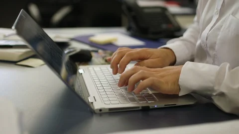 Slow motion shot of male office worker typing on notebook at his desk. Stock Footage 87635204