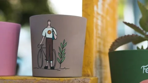 Slow Motion Shot of a Man with a Bicycle Painted on Clay Pot Stock Footage 218381845