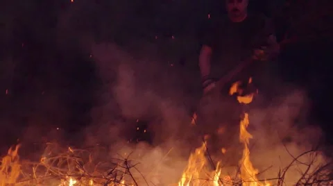 Slow motion shot of man burning dry branches on the bonfire Stock Footage 63907011