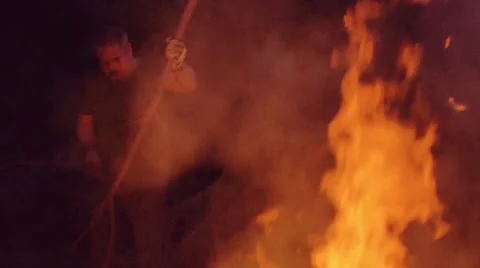 Slow motion shot of man burning dry branches on the bonfire Stock Footage 63907316
