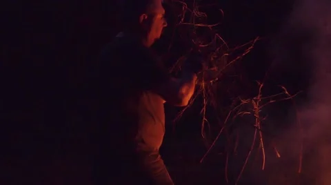 Slow motion shot of man burning dry branches on the bonfire Stock Footage 63907574