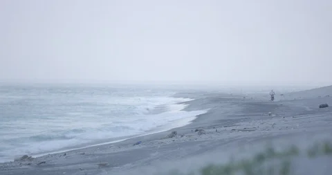Slow motion shot of man driving motorbike on sandy beach near sea in morning Stock Footage 125829591