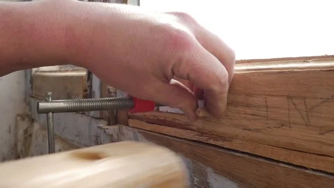 Slow motion shot of Man hand drive in wooden dowel in polished wooden board by Stock Footage 152831733