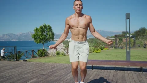 Slow motion shot of a man having cardio training outdoors and throwing skipping Stockbeeldmateriaal 199689244