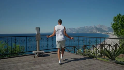 Slow motion shot of a man having cardio training outdoors and throwing skipping Видео 199689662