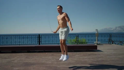 Slow motion shot of a man having cardio training outdoors and throwing skipping Vidéo 200137157