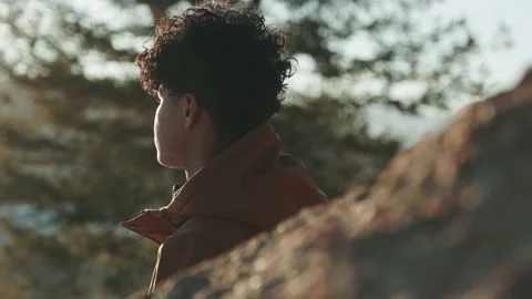 Slow motion shot of man looking into the sunset before eventually turning back t Vidéo 234356784