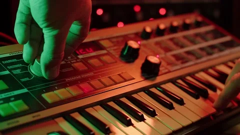Slow motion shot of a man playing keys and turning knobs on a vintage 動画素材 147237454