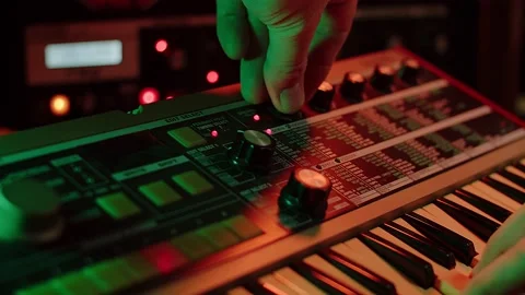 Slow motion shot of a man playing keys and turning filter knobs on a 動画素材 147237511