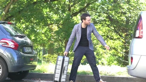 Slow motion shot of man putting luggage in back of car Stock Footage 75189124