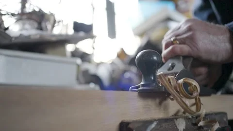 Slow motion shot of man shaving a piece of wood in a workshop Stock Footage 175198345