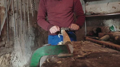 Slow Motion shot of a man using a manual wood planer tool Stock Footage 147049830
