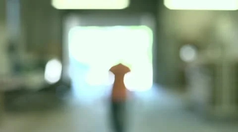 Slow motion shot of man walking up to camera in a workshop Stock Footage 11016534