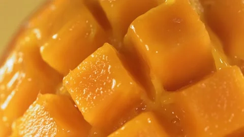 Slow Motion Shot of Mango Juice Splashing through Mango Cube Slices Vidéo 228671512