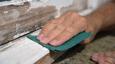 Slow motion shot of a man's hand sanding the edge of a worn window sill Vídeos de archivo 119434387