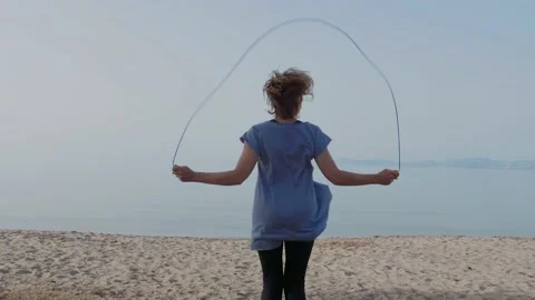 A slow-motion shot of a middle-aged woman exercising with a jumping rope Stock Footage 130473726