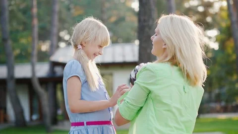 Slow motion shot: Mom puts on a protective helmet for her daughter. Concept - Stock Footage 79957992