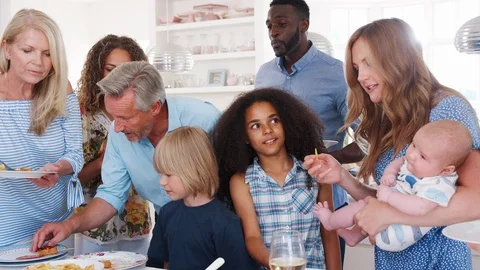 Slow Motion Shot Of Multi-Generation Family And Friends Gathering In Kitchen For Stock Footage