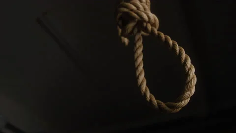 Slow motion shot of noose from hemp rope hanging in dark room Stock Footage 208796522