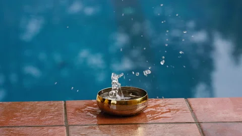 Slow motion shot of an object dropping into a bowl and water splashes out Stock Footage 231461182