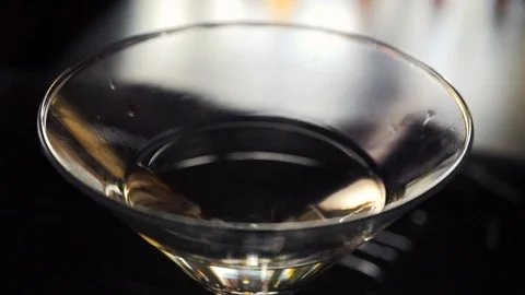 Slow motion shot of olive splashing into martini Stock Footage 112700827