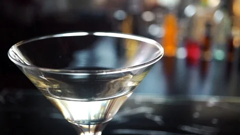 Slow motion shot of olive splashing into martini Stock Footage 112700842