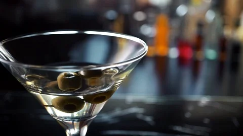Slow motion shot of olive splashing into martini Stock Footage 112700854