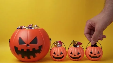 Slow motion shot picking small halloween pumpkin head basket with candy Stock Footage 209332856