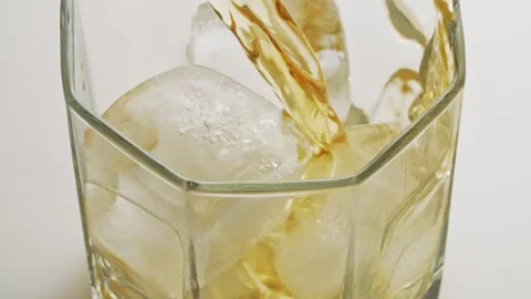 Slow Motion Shot of Pouring Ice Tea or whisky into Glass with Ice Stock Footage 147356115