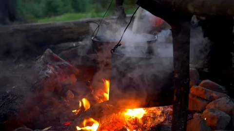 Slow motion shot of preparing food in pot on campfire Stock Footage 79725939