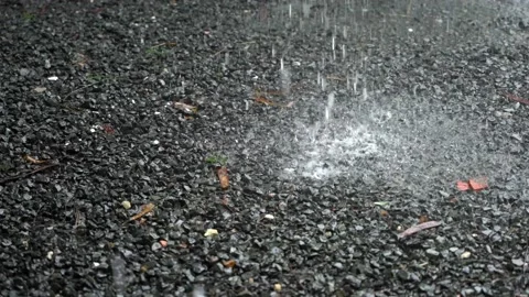 Slow motion shot of raindrops falling on the gravel ground. Rainy season Видео 199547144