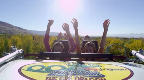 Slow motion shot of riders the hood of a roller coaster car Stock Footage