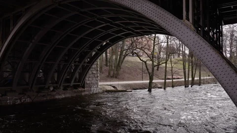 Slow motion shot of a river that runs under an old steel bridge 2 Stock Footage 273955459
