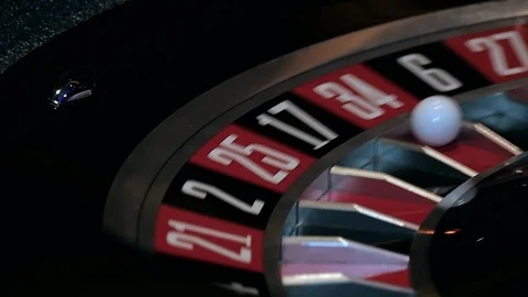Slow motion shot of a roulette table spinning and ball landing in red 34 Stock Footage 112005766