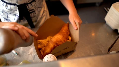 A slow-motion shot of salt and pepper being added to fish and chips! Stock Footage