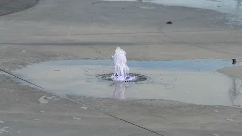Slow-motion shot of a small water fountain with purple light. Video stock 220607679