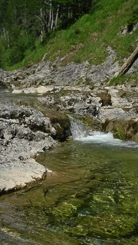 Slow motion shot of a small waterfall from a mountain stream, vertical Video stock 260876448