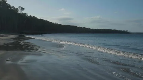 Slow Motion shot of small wave crashing on beach Stock Footage 297715726