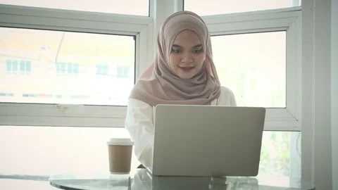 Slow motion shot of smiling Muslim woman holding credit card using laptop doing Stock Footage 254490611