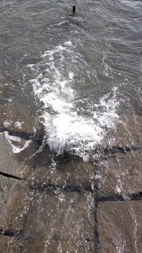 Slow motion shot of a stream flowing through a concrete chute into a lake Video stock 267437022