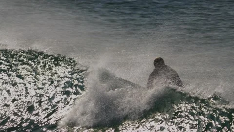 Slow motion shot of surfer trying to catch wave and stand up on the surf Stock Footage 231479025