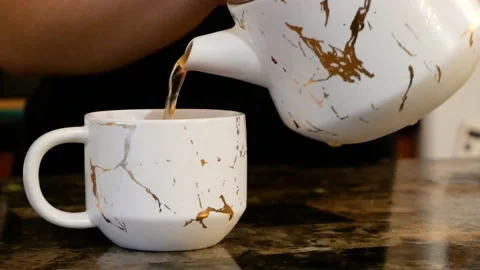 Slow Motion Shot of Tea Being Poured Into a Marble Cup Stock Footage 161670874