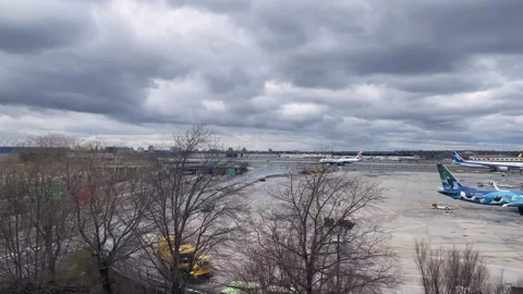 SLOW MOTION SHOT OF TERMINAL 3 JFK AIRport during cloudy day from train Stock Footage 241378691