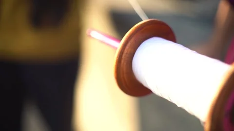 Slow motion shot of thread being pulled quickly from charkhi spool as an out of Stock Footage 144041364