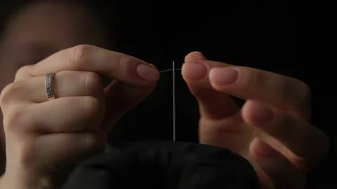 Slow motion shot of thread passing through sewing needle. woman sewing project b Stock Footage 151323203