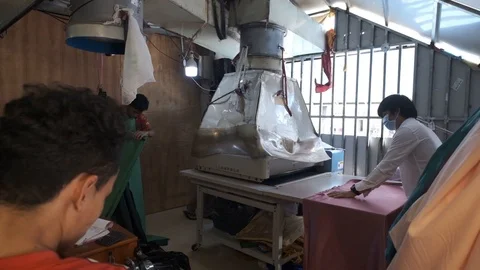 Slow motion shot of three workers with a large pressing machine handling a Stock Footage 118638566