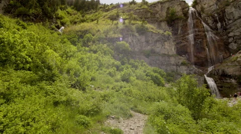 Slow motion shot tracking towards waterfall surrounded by green Stock Footage 52498999