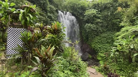 Slow motion shot of tropical waterfall and traditional shrine in Bali Stock Footage 338286910